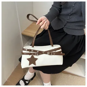 Detailed shot of stylish white brown crossbody bag with unique star pendant and double straps.