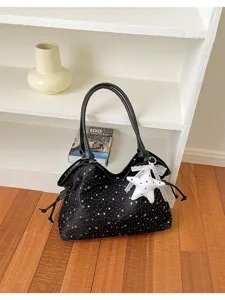 Detailed view of the black star print tote bag with stylish leather straps and star pendant.