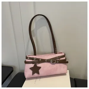 Close-up view of stylish pink shoulder bag featuring brown straps and star pendant detail.