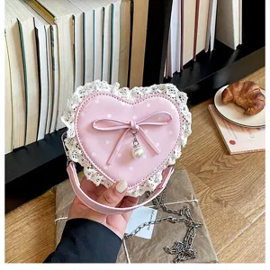 Close-up of pink heart-shaped kids bag featuring white polka dots and delicate lace trim.