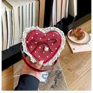 Red heart-shaped children handbag with white polka dots, lace trim and bow detail.