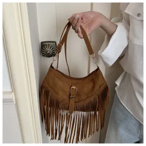 Brown suede fringe detail handbag, retro bohemian style shoulder bag close-up view.