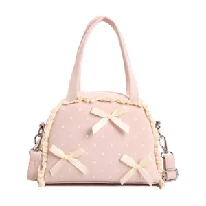 Rosa Handtasche mit weißer Spitze, süßen Schleifen, Pünktchen-Muster und praktischem Schultergurt.