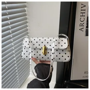 White polka dot shoulder bag detail, elegant gold metal clasp and smooth surface.