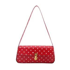 Red polka dot shoulder bag for women, chic vintage baguette handbag with golden lock.