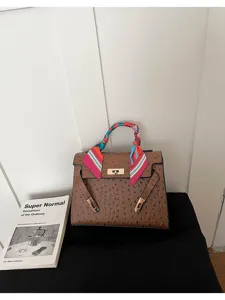 Bolso de hombro marrón con textura de avestruz y elegante pañuelo twilly colorido.