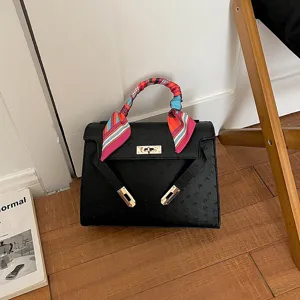 Elegante bolso de mano negro con patrón de avestruz y pañuelo colorido para estilo diario.