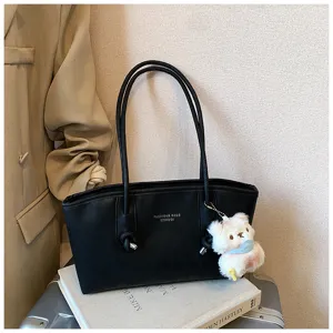 Black leather tote bag for women, stylish underarm shoulder bag with cute plush bear charm.