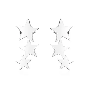 Vista detallada de pendientes minimalistas de acero inoxidable con tres estrellas.