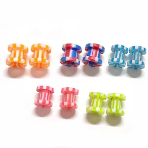 Nahaufnahme Detail von bunten gestreiften Acryl Ohrringen und Tunneln für Körperschmuck.