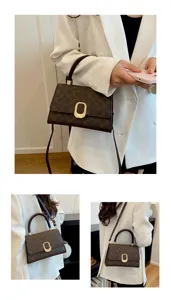 Vista detallada del bolso de hombro marrón con monograma, elegante bolso para trabajo.