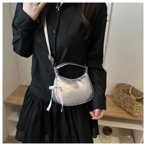 Bolso plateado metalizado de lunares con lazo rosa y detalle de cinta decorativa.