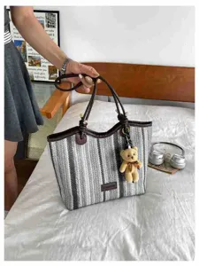 Striped straw tote bag for women, large capacity beach vacation shoulder bag with cute bear pendant.