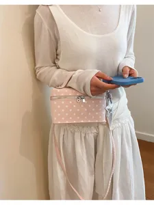 Detail view of the cute pink polka dot box bag, stylish crossbody design with smooth zipper.