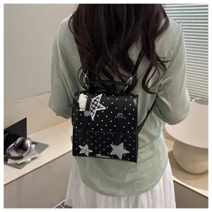 Close-up detail view of the fashionable polka dot mini backpack featuring cute star embroidery.