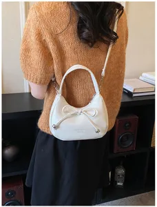 Dettaglio borsa a spalla con fiocco bianco con design elegante e materiale in PU.