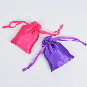 Close-up of pink and purple satin drawstring pouches for jewelry packaging