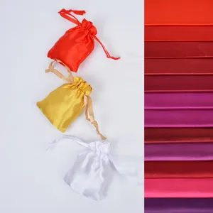 Detailed close-up of silky satin drawstring bags and colorful fabric material swatches