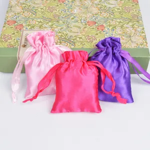 Colorful satin drawstring pouches in pink, rose, and purple for jewelry packing.