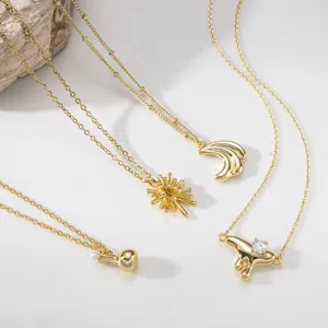 Close-up detail shot of delicate gold layered necklaces featuring unique pendants and shiny zircon.