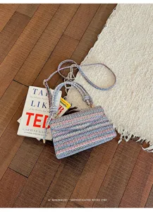 Primo piano dettagliato della borsa a tracolla tessuta etnica con righe colorate uniche.