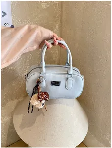 Detail view of the stylish light blue bowling handbag, featuring metal plate and cute plush charm.
