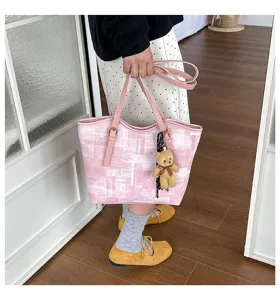 Detail view of the pink patterned tote bag with cute teddy bear plush charm and straps.