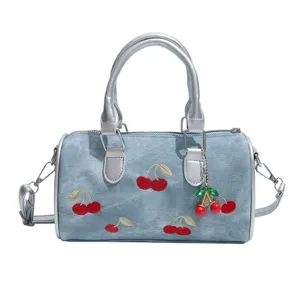 Blue denim Boston handbag with cute cherry embroidery and pendant, stylish commuter crossbody.