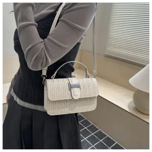 Gedetailleerd overzicht van stijlvolle beige geweven crossbody tas met handvat en gesp.