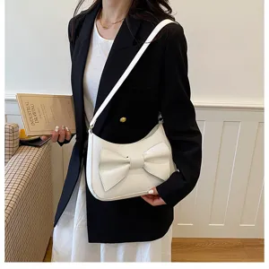 Close-up detail of stylish white underarm shoulder bag with elegant bow design for daily wear.