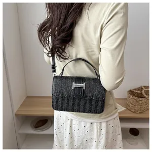 Zwarte stro geweven crossbody tas detail, stijlvolle geweven handtas voor dames zomermode.