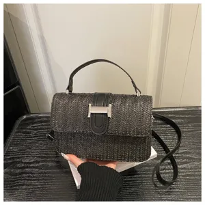 Detail van de zwarte gevlochten strooien kleine vierkante tas, zomer mode crossbody.