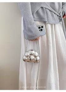Gros-plan d'un sac bandoulière nuage en métal argenté avec une chaîne chic et un style pur.