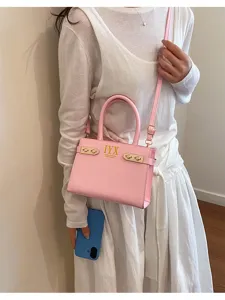 Trendy pink leather shoulder bag with chic metal lock hardware and top handle design.