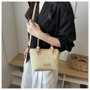 Woven straw bucket bag with PU leather handle and crossbody strap, chic beach style handbag.