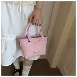 Pink woven bucket handbag with knot handles, beach style straw crossbody bag for women detail