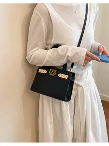 Detail of the black structured shoulder handbag with golden hardware for stylish daily wear.