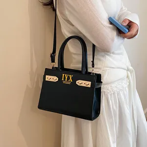 Stylish black leather shoulder bag with chic metal hardware and top handles for women.