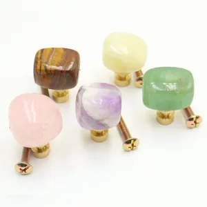 Detailed view of natural crystal stone cabinet door handles with solid brass bases and screws.