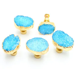 Close-up detail shot of blue crystal druzy cabinet knobs with luxury gold electroplated base.