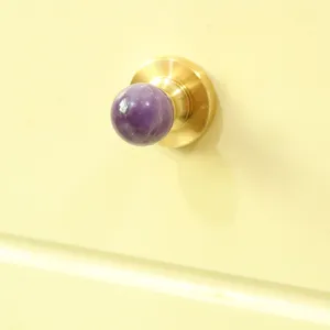 Detail shot of luxury natural amethyst crystal cabinet knob with brass base furniture hardware