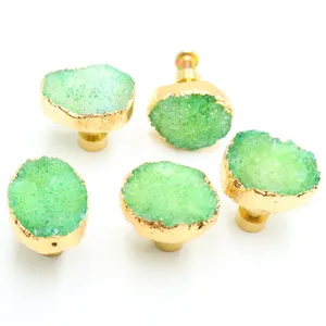 Close-up of green natural crystal agate stone drawer pull with gold edge and brass base.