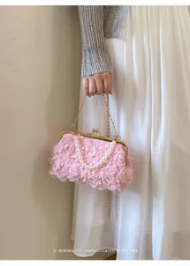 Vue détaillée de l'élégante pochette florale rose avec perles et chaîne dorée.