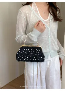 Gros plan détail du sac de soirée rose en tulle noir avec poignée perle et chaîne dorée.