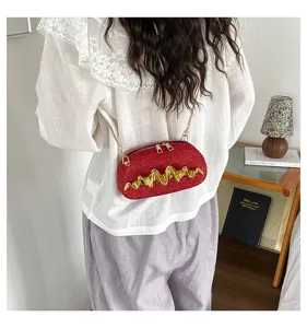 Rote Pailletten Umhängetasche Detailansicht, mit goldener Kette und tollem Wellenmuster.