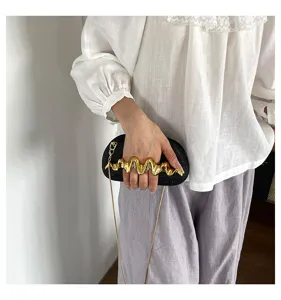 Modische schwarze Damen Clutch Tasche mit goldenem Knöchelgriff und Kette für schicke Alltagsoutfits.