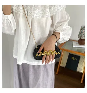 Schicke schwarze Glitzer Umhaengetasche mit goldenem Wellen Griff fuer Damen.