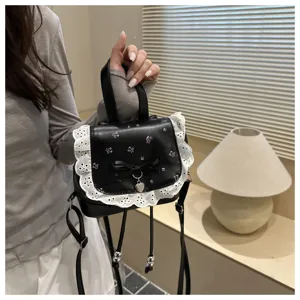 Zaino mini nero con stampa floreale, bordo in pizzo bianco, fiocco e ciondolo a cuore.