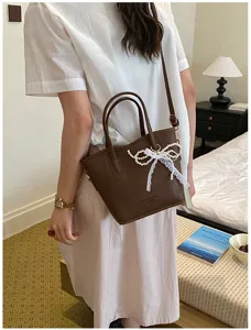 Stylish women brown bucket bag with pearl bow, casual commuter tote handbag for daily use.