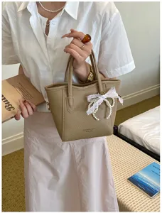 Casual khaki bucket bag for women with pearl lace bow pendant, stylish commuting handbag.